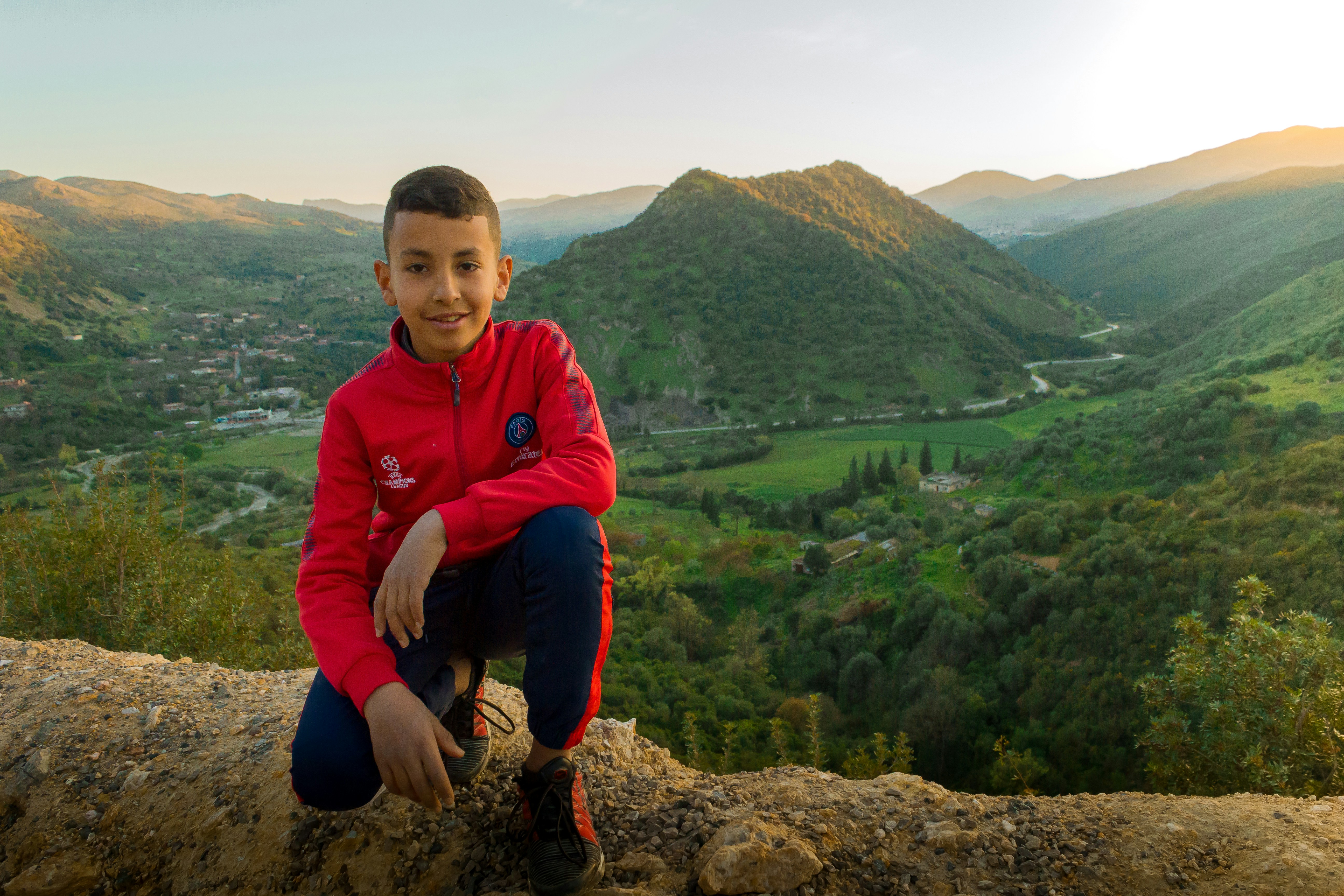 A young boy wearing red sport jacket during daytime